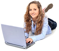 Meisje dat liggend een laptop gebruikt